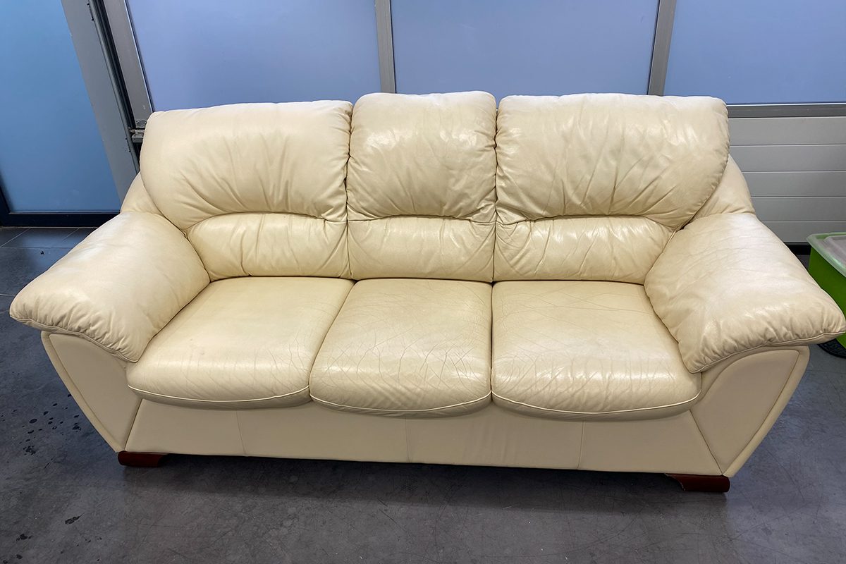 trzyosobowa sofa skórzana w jasnym kolorze przed odnowieniem